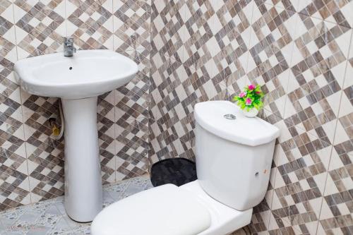 a bathroom with a white toilet and a sink at Large Stylish 2 Bedroom Flat in Kumasi