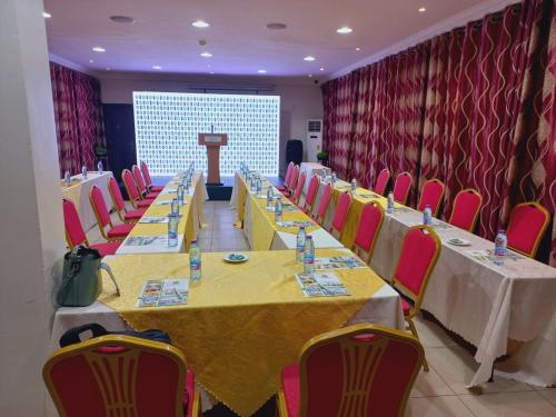a conference room with long tables and chairs and a podium at Airport West Hotel in Accra
