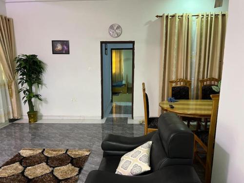 a living room with a table and a couch at Large Stylish 2 Bedroom Flat in Kumasi