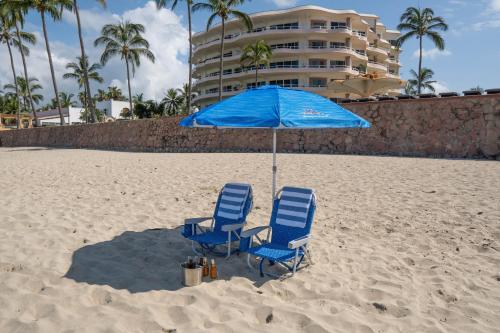 two chairs and an umbrella on the beach at Ocean Front, With Pool, 6 People, Quinta del Mar PH502 in Bucerías
