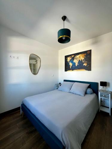 - une chambre avec un lit et une lampe pendant dans l'établissement Villas Oléron à 50m de la plage, à La Brée-les-Bains