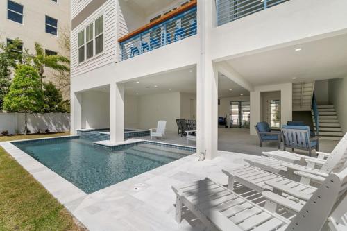 una casa con piscina y dos sillas en Akoya House at The Gemma by Brightwild, en Clearwater Beach