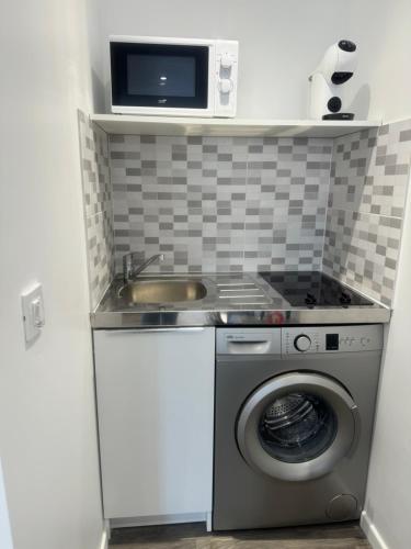 une petite cuisine avec un évier et une machine à laver dans l'établissement Estrella, à Savigny-sur-Orge