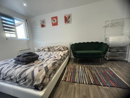 - une chambre avec un lit et une chaise verte dans l'établissement Estrella, à Savigny-sur-Orge