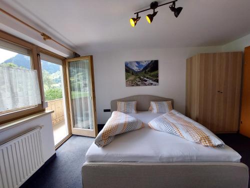a bedroom with a bed with pillows on it at Landhaus Irena - Familienfreundliches Ferienhaus an der Zillerpromenade mit Bergblick in Ramsau im Zillertal