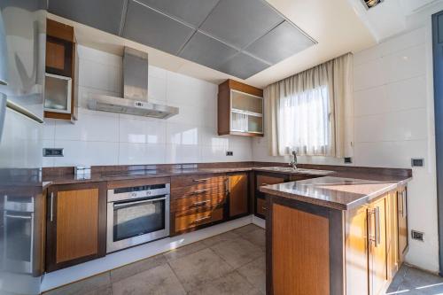 Una cocina grande con gabinetes de madera y fregadero. en Casa Bohème, en Santa Susanna