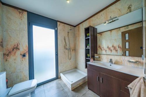 Un baño con inodoro, lavabo y ducha. en Casa Bohème, en Santa Susanna