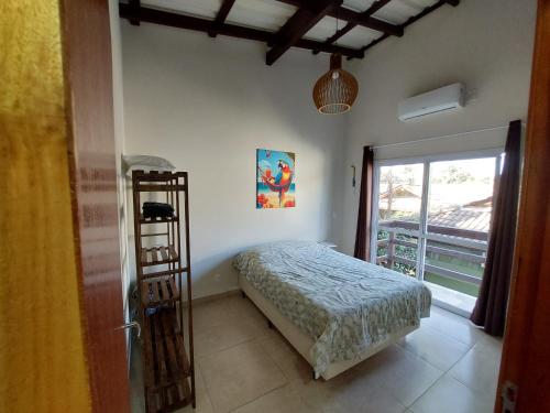 a bedroom with a bed and a ladder and a window at Floripa Beach House Hostel in Florianópolis