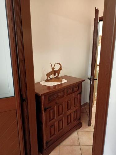a wooden cabinet with a statue on top of it at B&B Bourg in Donnas