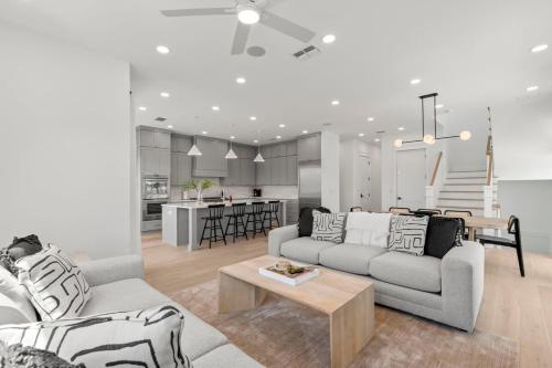 a living room with two couches and a table and a kitchen at Jade House at The Gemma in Clearwater Beach