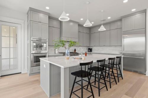 a kitchen with white cabinets and a large island with bar stools at Jade House at The Gemma in Clearwater Beach