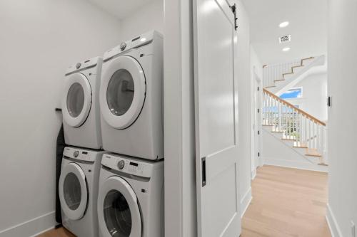 a laundry room with two washing machines and a refrigerator at Jade House at The Gemma in Clearwater Beach