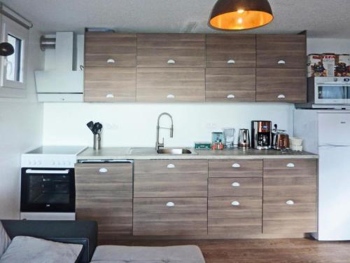 une cuisine avec des armoires en bois et un évier dans l'établissement Résidence La Mazeliere - Appartement pour 8 personnes entièrement rénové MAE-3694, à Le Mélézet