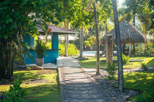 a path through a garden with a thatched hut at Beach Break Resort & CR Surf Camp in Jacó