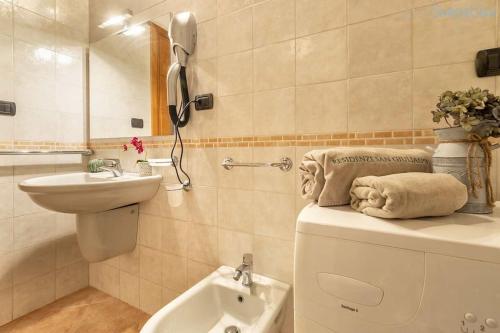 a bathroom with a toilet and a sink and a phone at Olivastri Cottage with pool in the Nature Park of Porto Conte in Santa Maria la Palma