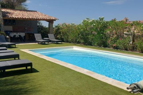 une piscine avec des chaises longues et une maison dans l'établissement Villa les Lauriers, à Valensole