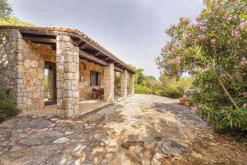 an external view of a stone house with a road at Olivastri Cottage with pool in the Nature Park of Porto Conte in Santa Maria la Palma