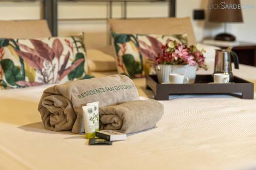 a bed with a towel and a book on it at Olivastri Cottage with pool in the Nature Park of Porto Conte in Santa Maria la Palma