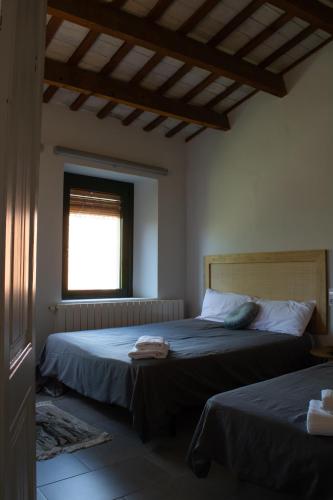 a bedroom with two beds and a window at Can Paulí in Ultramort