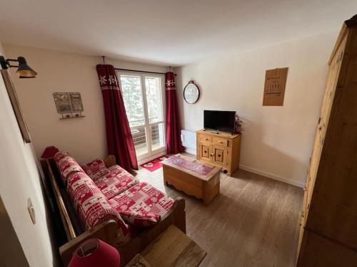 un salon avec un canapé et une télévision dans l'établissement Praloup 1500 Appart 4 couchages, à Uvernet