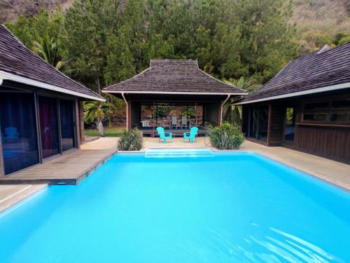 a swimming pool in front of a house at Pool Mountain Moorea in Moorea