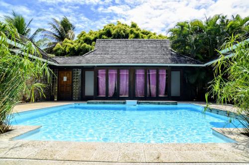 a swimming pool in front of a house at Pool Mountain Moorea in Moorea