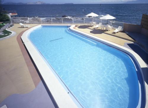 una piscina con el océano en el fondo en Ako Onsen Shokichi, en Ako