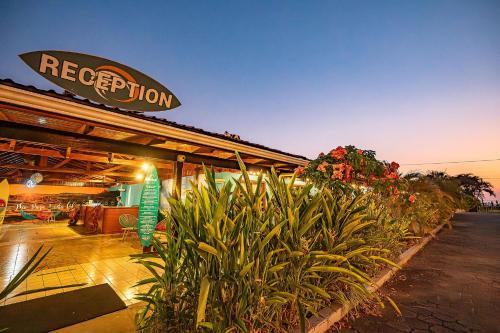 a restaurant with plants in front of a building at Beach Break Resort & CR Surf Camp in Jacó