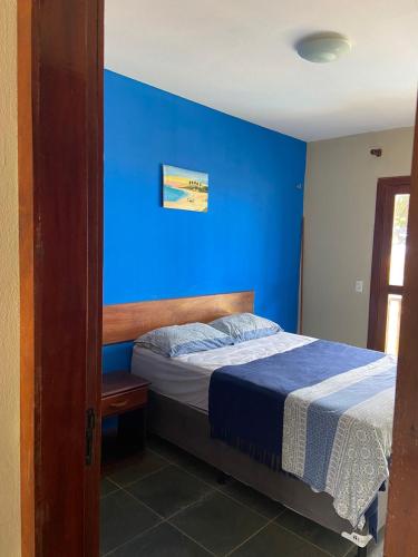 a blue bedroom with a bed with a blue wall at Residencial Sirius Canoa in Canoa Quebrada