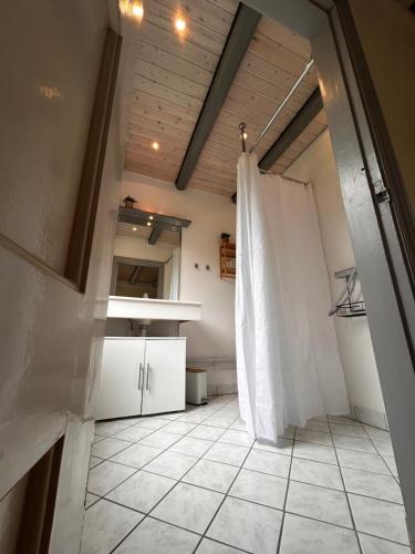 a room with a kitchen with a white curtain at Strandidyl Bed and Breakfast in Haderslev