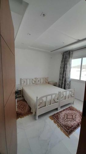 sypialnia z białym łóżkiem i oknem w obiekcie Appartement Kelibia w mieście Kelibia