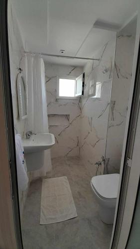 łazienka z toaletą i umywalką w obiekcie Appartement Kelibia w mieście Kelibia