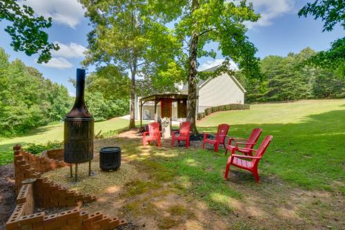 a group of red chairs and a grill in a yard at Cleveland Retreat with Deck 2 Mi to Winery! in Cleveland