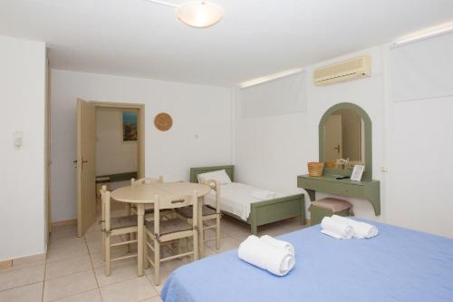 a room with two beds and a table and a table at Blue Marine Village in Chalkida
