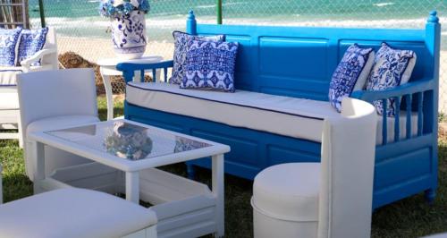 a blue bench with pillows and a table and chairs at Hotel Best Beach- Family Only in Chott Meriem