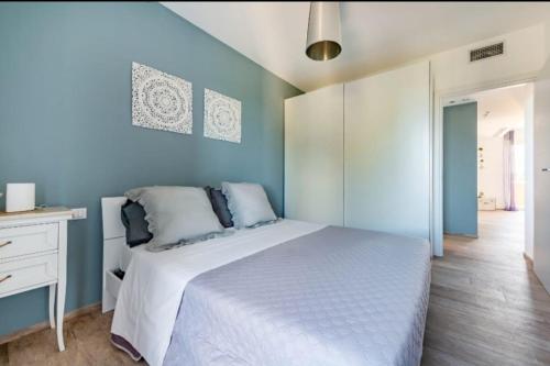 una camera con un letto bianco e una parete blu di Maison Costa del Sol - Capitolo, Monopoli a Monopoli