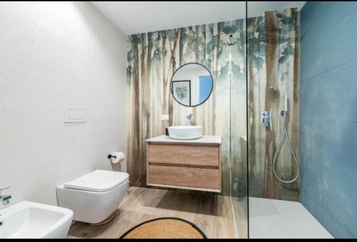 un bagno con un water, un lavandino e uno specchio di Maison Costa del Sol - Capitolo, Monopoli a Monopoli