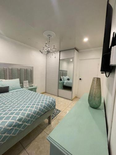a bedroom with a bed and a table with a vase at Jazmin's Apartment in Oranjestad