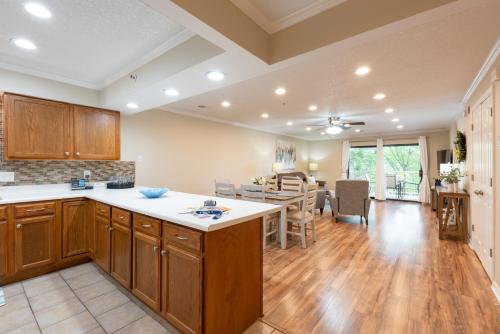 a kitchen and living room with wooden cabinets and a table at 2BR Walk-In Condo - Near the 76 Strip - 2 Pools - FREE TICKETS INCLUDED - FHF-11 in Branson