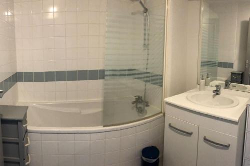 une salle de bain avec une baignoire et un lavabo dans l'établissement Appartement proche centre ville, à Saumur