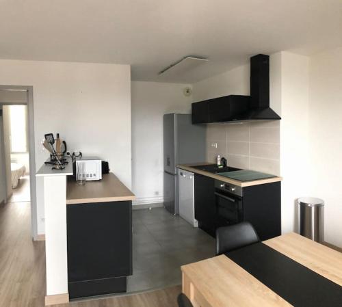 - une cuisine avec des appareils en noir et blanc dans l'établissement Appartement proche centre ville, à Saumur