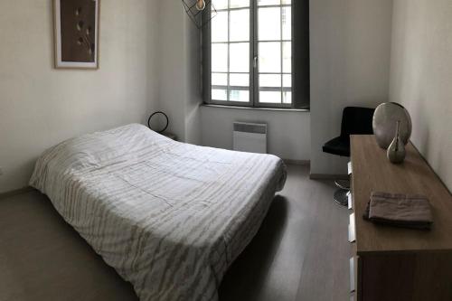 une chambre avec un lit, un bureau et une fenêtre dans l'établissement Appartement proche centre ville, à Saumur