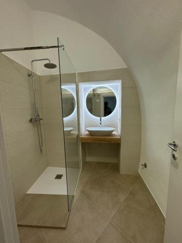 a bathroom with a sink and a glass shower at Les Petites Maisons in Rodi Garganico