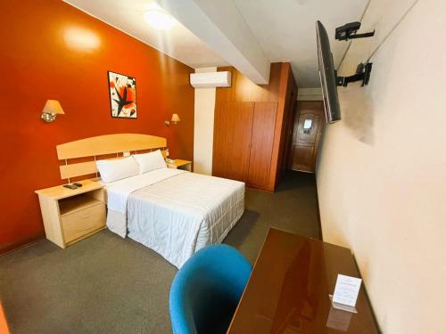 a hotel room with a bed and a desk and a tv at HOTEL Javier Prado Inn in Lima