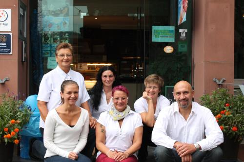 a group of people sitting in front of a building at Hotel Adlerhof in Tauberbischofsheim