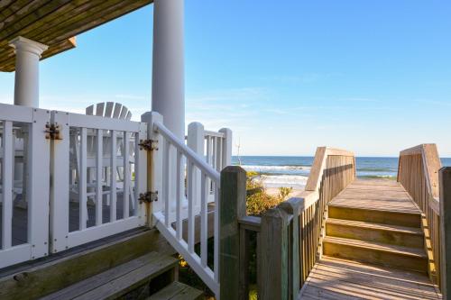 a house with a wooden staircase leading to the beach at My Blue Haven in North Topsail Beach
