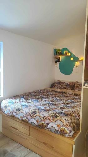 - une chambre avec un lit avec un poisson sur le mur dans l'établissement Maison de Pêcheur, à Piriac-sur-Mer