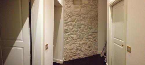 a hallway with a stone wall next to a door at Il Duomo Relais in Ragusa