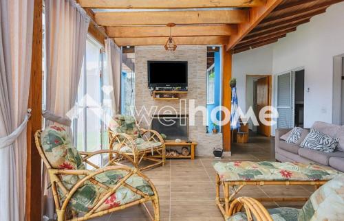 a living room with a couch and chairs and a tv at Chácara Mig&Vá in Itupeva