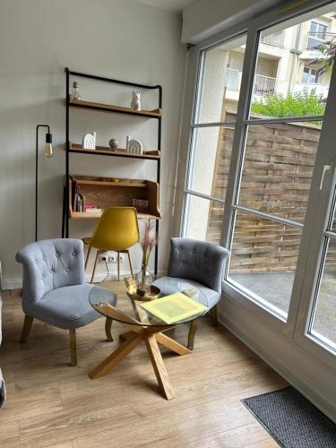 a living room with two chairs and a table and a window at La Pléiade Dorée - Extra Centre - Wifi HD - Terrasse & Jardin in Amiens